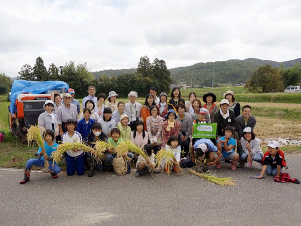 稲刈りの後、コープネットの参加者とコープにいがたの組合員14名、佐渡Kids生きもの調査隊の子どもたちとで記念撮影。