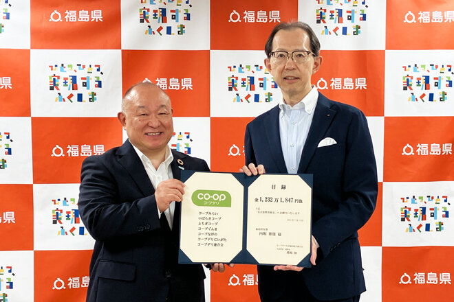 福島県の内堀雅雄知事（右）に目録を渡す、熊﨑伸代表理事理事長