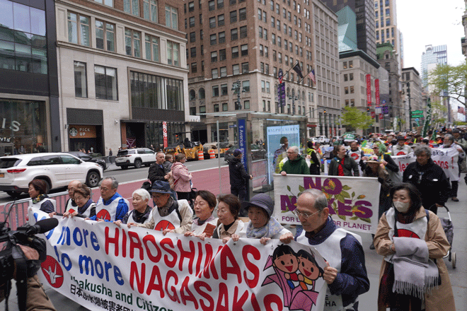 「No more HIROSHIMAS, No more NAGASAKIS」の横断幕を掲げて平和行進をしました