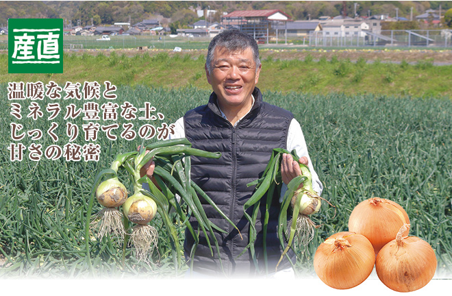 たまねぎを掲げ持つ榎本精治さんの写真